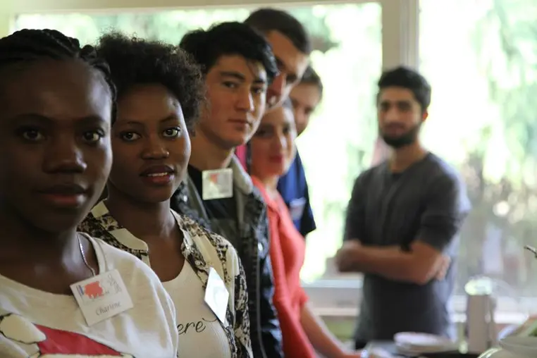 Un groupe de jeunes adultes réunis en atelier, badge nominatif au revers.